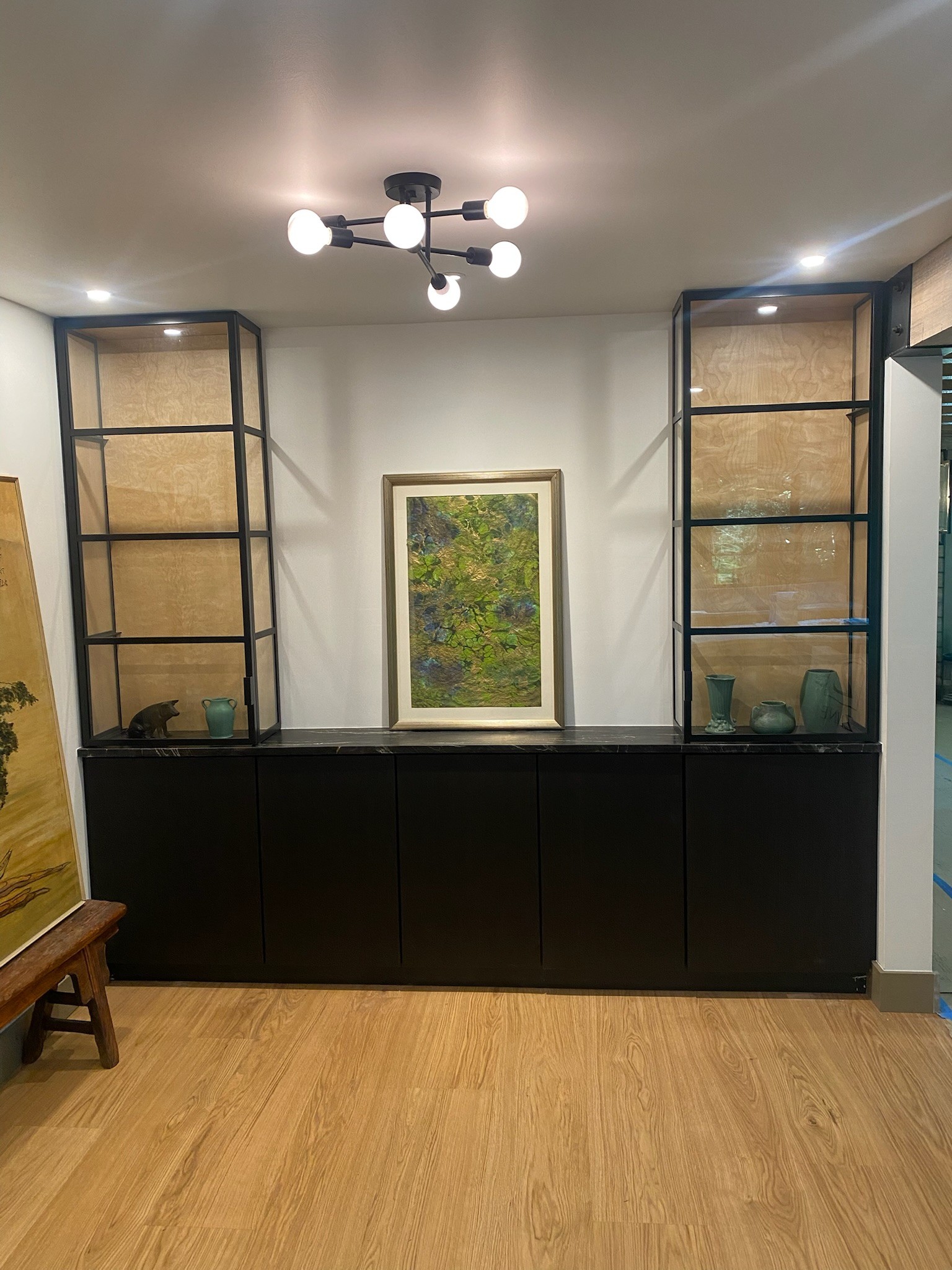 Built-in shelving units flanking a cabinet with a stone top